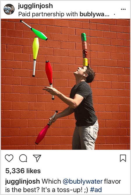 Josh Horton žongluje s kluby, které odpovídají barvám čtyř vodních plechovek Bubly naskládaných na jeho hlavu. Pozadí je cihlová zeď. Na fotografii je reklama, kterou vytvořil Josh pro vodu Bubly a zveřejnil ji ve svém kanálu Instagram s popisem, která chuť vody Bubly je nejlepší? Je to nahoře!